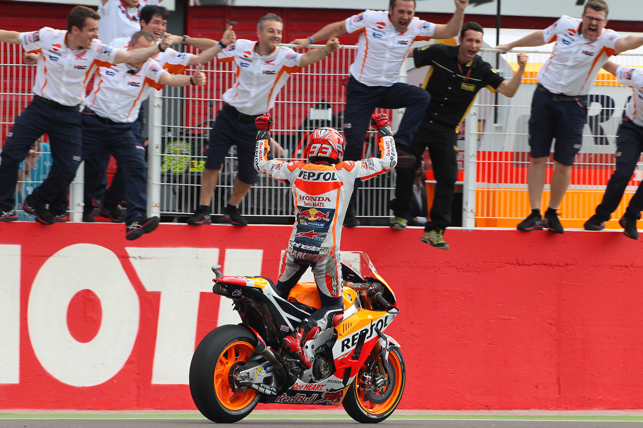 Marc Márquez levantado sobre la moto celebra con su equipo
