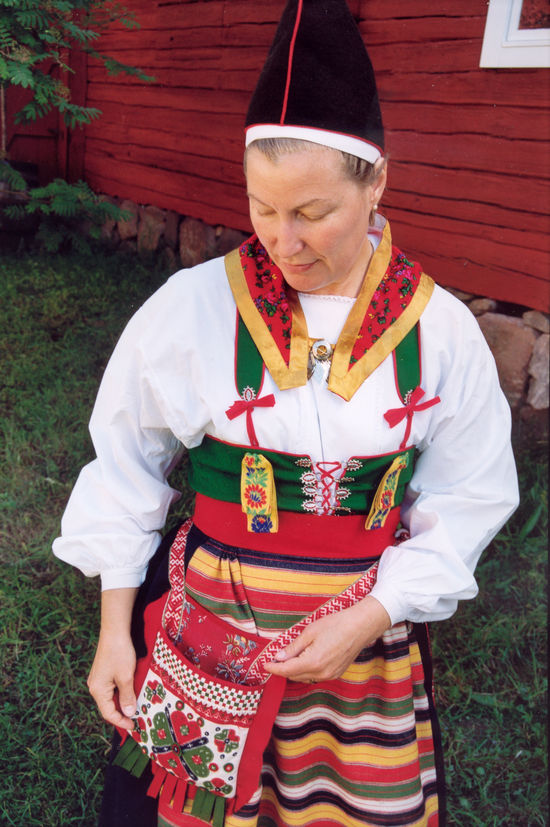 Folkdräkt med dkjolsäck Kvinna i folkdräkt med tillhörande kjolsäck