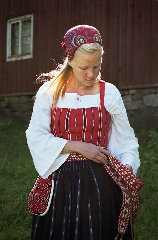 Folkdräkt med tillhörande kjolsäck Kvinna i folkdräkt med tillhörande kjolsäck