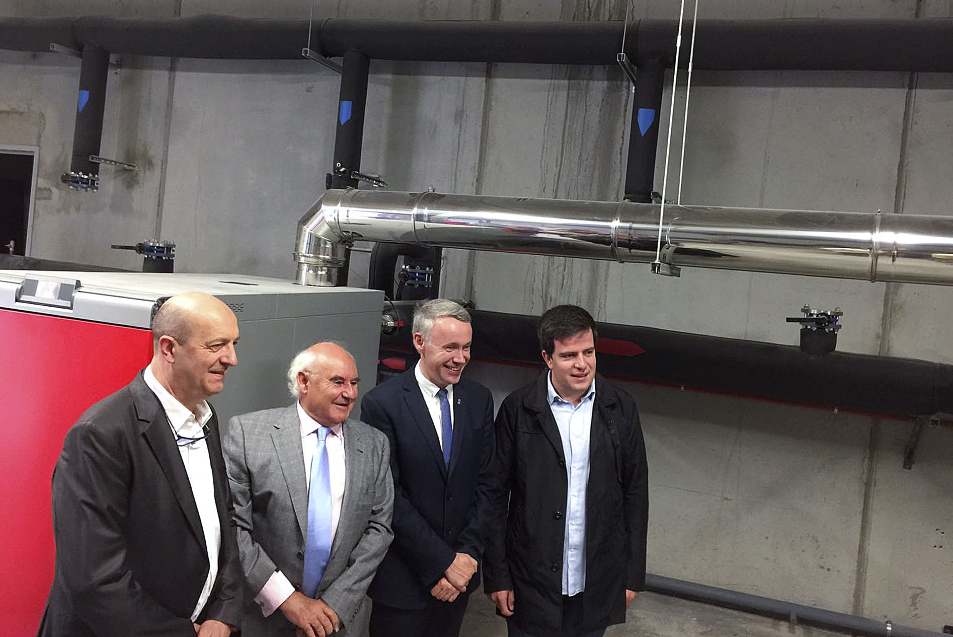 Miquel Rovira, Carlos Fernández, Albert Piñeira i Joan Manso davant d'una de les calderes de biomassa