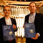 Pep Palau, que ha fet el pròleg i va participar en la presentació, al costat de Joaquim Comella Riera, sisena generació al capdavant de la família, amb un llibre a les mans
