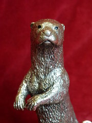silver standing otter on a naturalistic base.