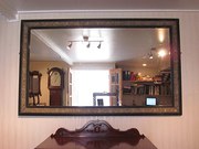 A LARGE EBONISED AND GILT MIRR