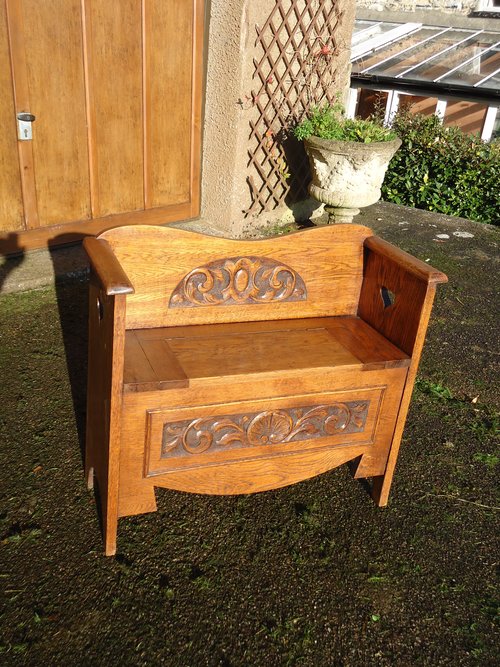 Arts & Crafts carved oak settle with storage