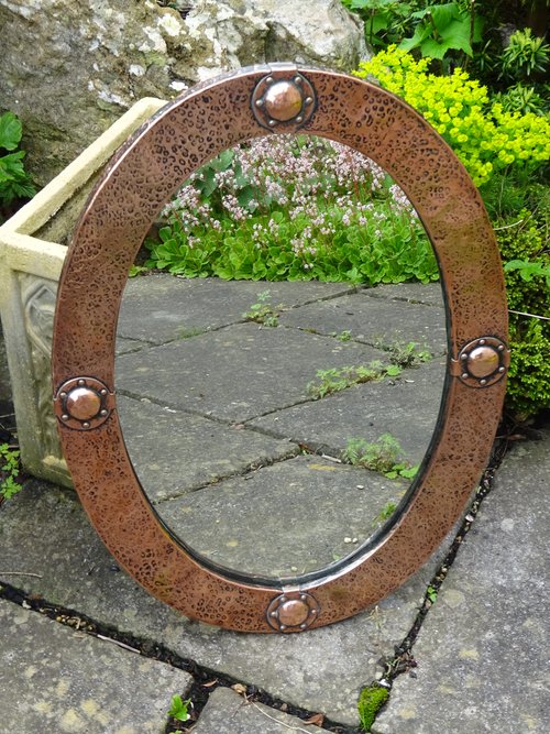 Arts & Crafts copper oval mirror with bosses