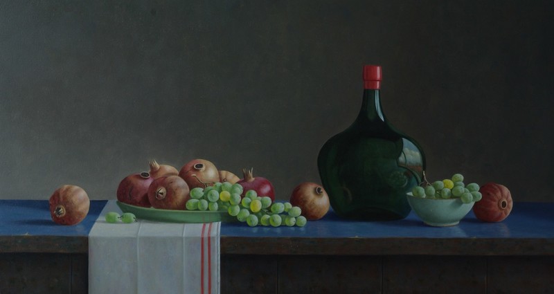 Druiven met granaatappels en groene fles