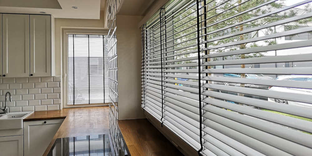 żaluzje drewniane na dużym oknie w kuchni