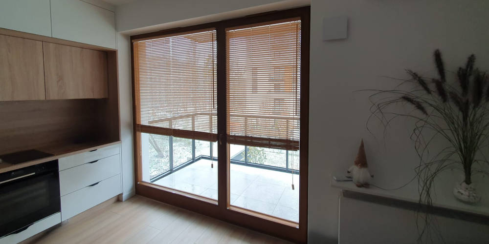 Żaluzje bambusowe 25 mm na oknie balkonowym