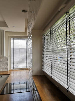 żaluzje drewniane na dużym oknie w kuchni