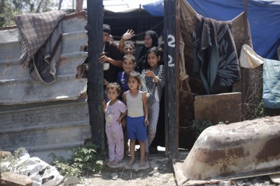 A family waves goodbye from temporary accommodation on the site of their former home, Beit Hanoun. Photo: Kuva: Anas Baba/Save the Children