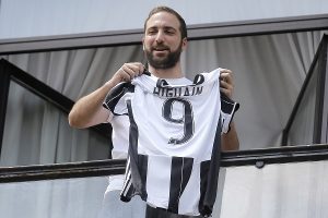 Juventus' forward Gonzalo Higuain from Argentina holds his jersey at the Juventus' headquarter in Turin on July 27, 2016. AFP PHOTO / MARCO BERTORELLO