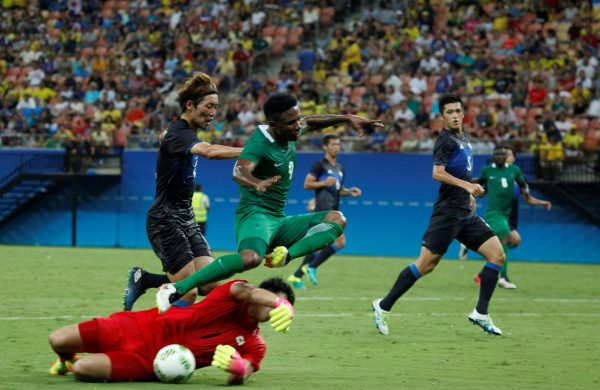 Nigeria's player Ezekiel leaps over Japan's goalkeeper Kushibiki during the Rio 2016 Olympic Games mens First Round Group B football match Nigeria vs Japan, at the Amazonia Arena in Manaus on August 4, 2016. / AFP PHOTO / RAPHAEL ALVES