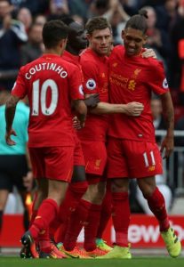 Liverpool's English midfielder James Milner is congrateulated by teammates after shooting from the penalty spot to score his team's fifth goal during the English Premier League football match between Liverpool and Hull City at Anfield in Liverpool, north west England on September 24, 2016. / AFP PHOTO / Geoff CADDICK / RESTRICTED TO EDITORIAL USE. No use with unauthorized audio, video, data, fixture lists, club/league logos or 'live' services. Online in-match use limited to 75 images, no video emulation. No use in betting, games or single club/league/player publications. /