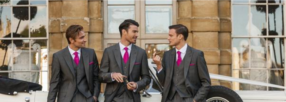 three men in dark grey suits with magenta ties