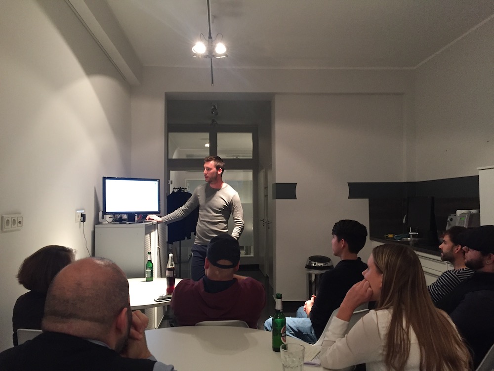 Pascal präsentiert am Bildschirm einen Vortrag über Produktivität, das Team schaut zu.