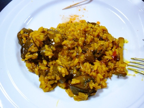 Arroz con carne de conejo y champiñones, con hierbas aromáticas.