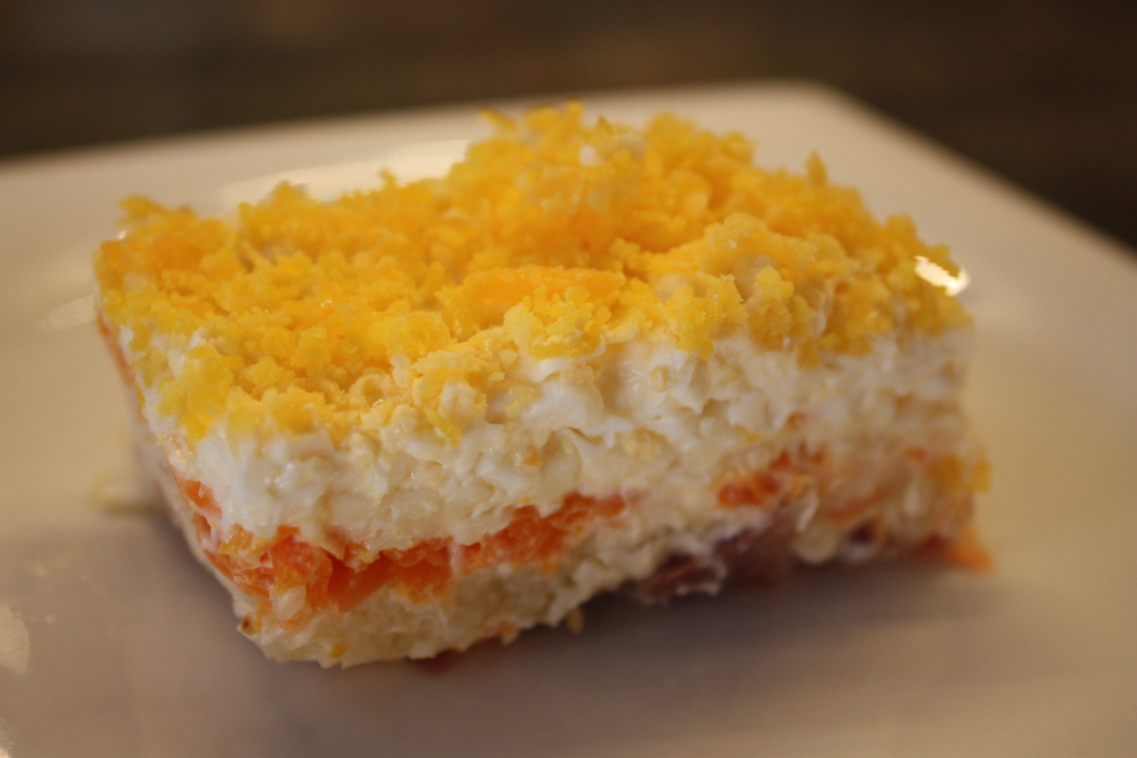 El Reloj de Cuco Pastel de ensaladilla, elaborado a base de sardinas en salmuera picada, zanahoria, patata, queso Emmental, y huevo rallado.