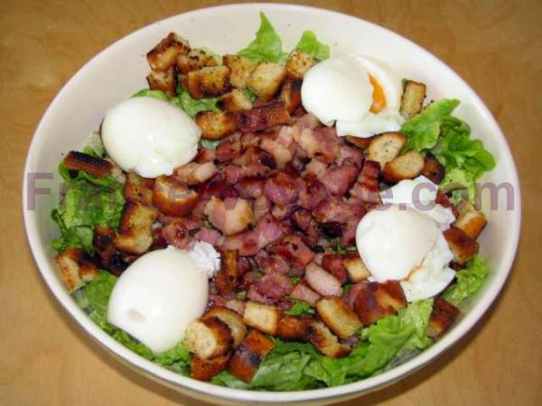 Esta suculenta ensalada de invierno une las virtudes de las hojas verdes con los croûtons de pan, la panceta, los arenques y el huevo poché por encima.