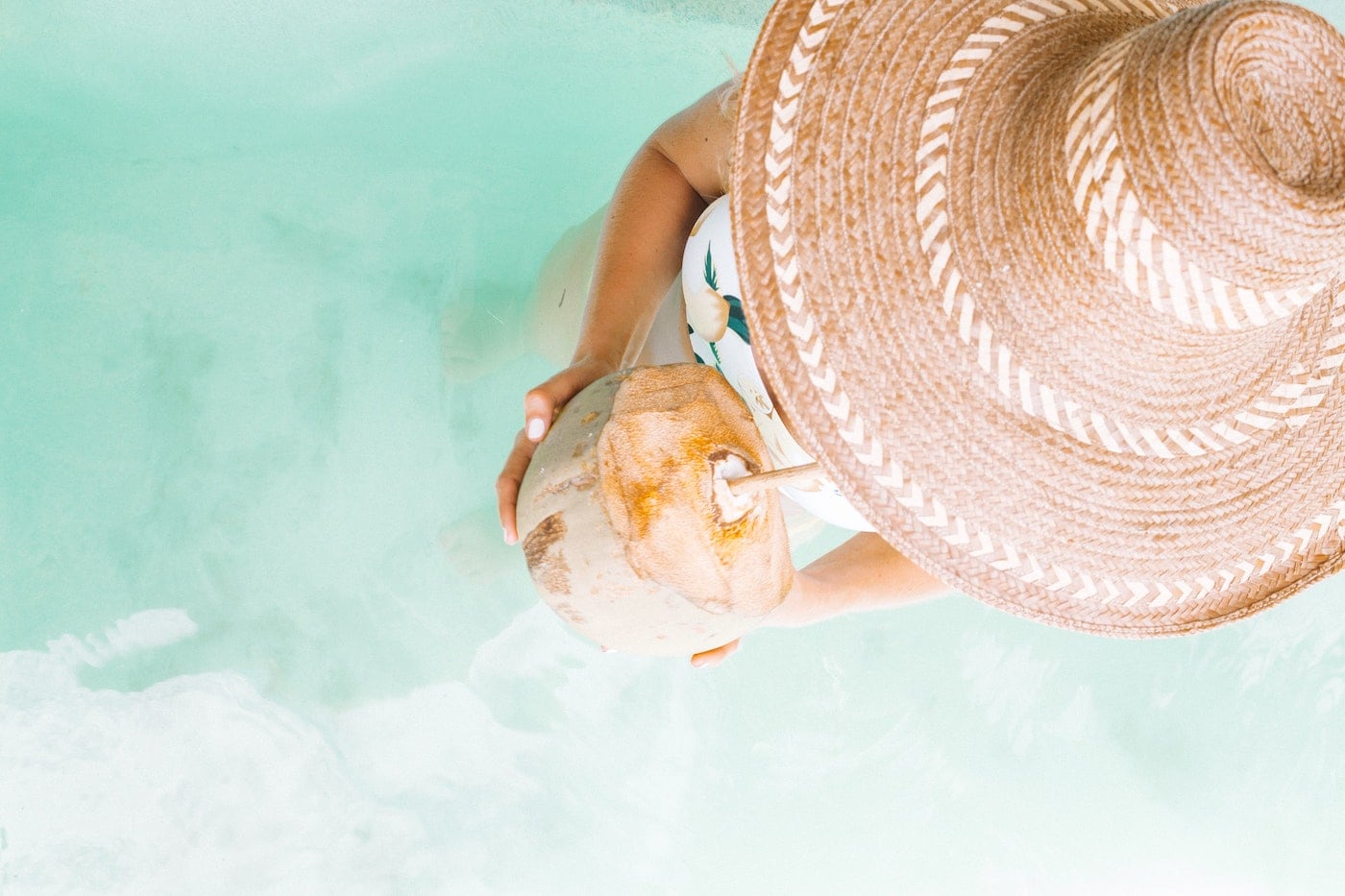 Woman Drinking a Coconut in the Caribbean Sea