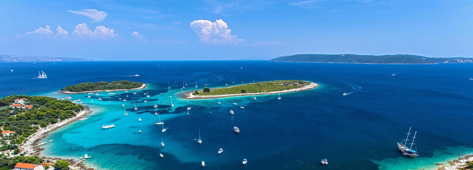 Yachts sailing in the crystal clear water of Krknjasi bay in Drvenik Veli in Croatia