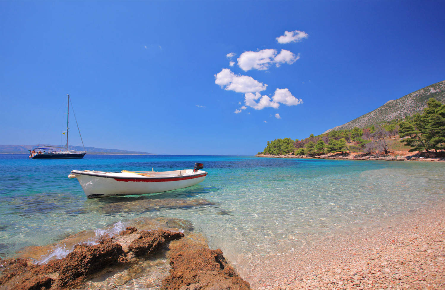 Charter yacht anchored in a bay of crystal clear water in the island of Brac in Croatia