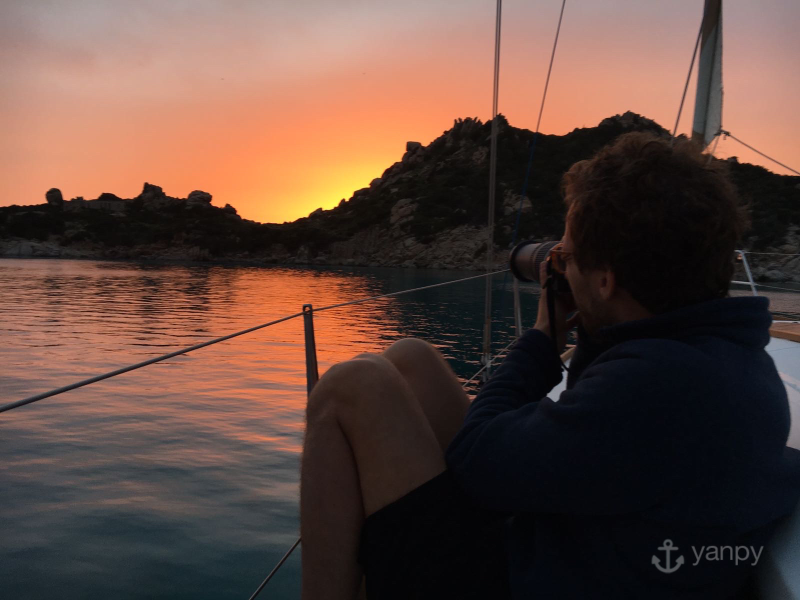 Yanpy crew taking pictures of the sunset from our sailboat in cala Corsara