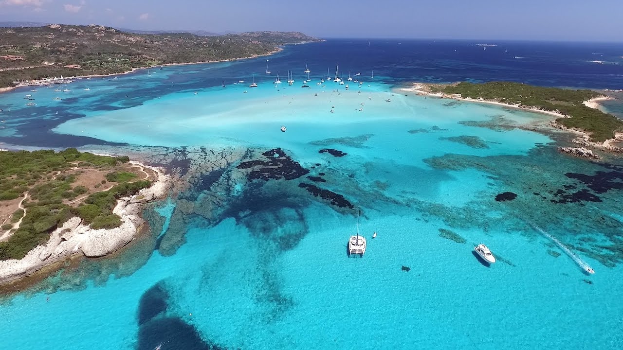 Charter yachts sailing in a paradise beach of crystal clear waterin Piana island (Corsica)