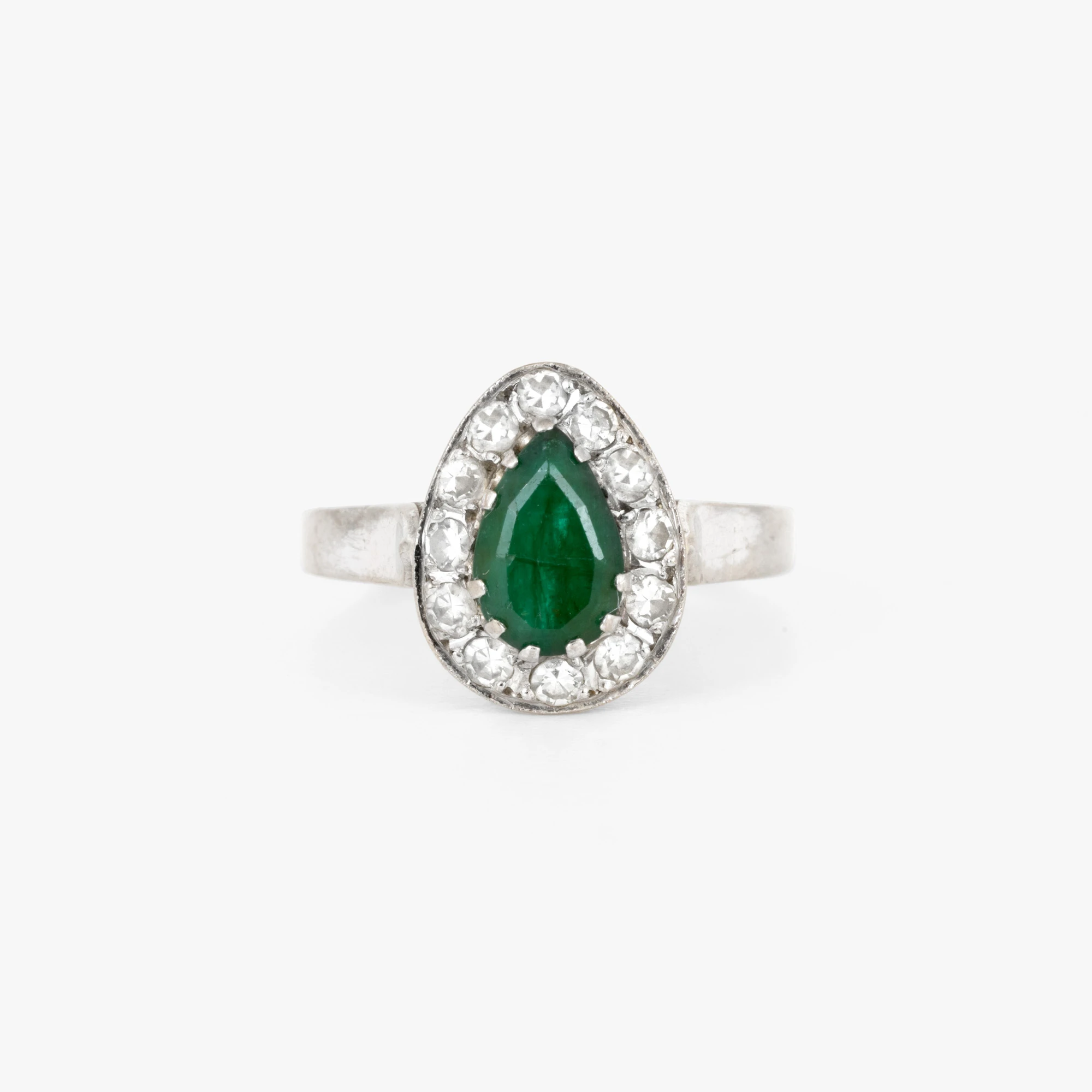 White gold ring decorated with emeralds and diamonds