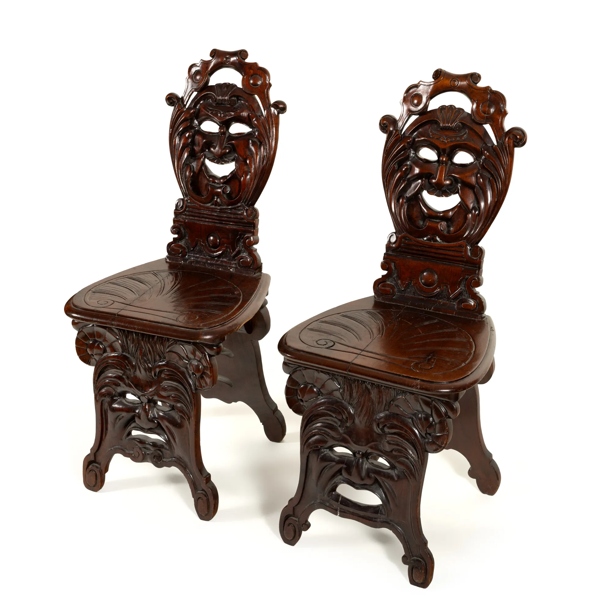 Pair of carved wooden chairs, decorated with mascherons, 19th century