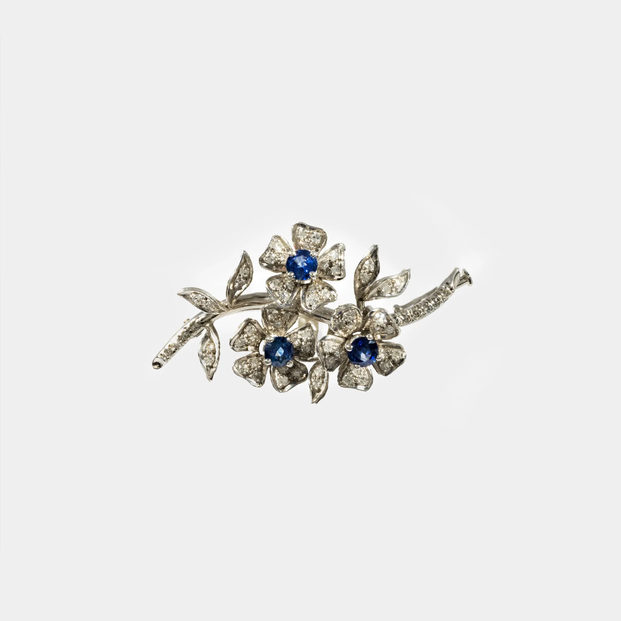 White gold brooch, decorated with sapphires and diamonds, in the form of a blooming branch
