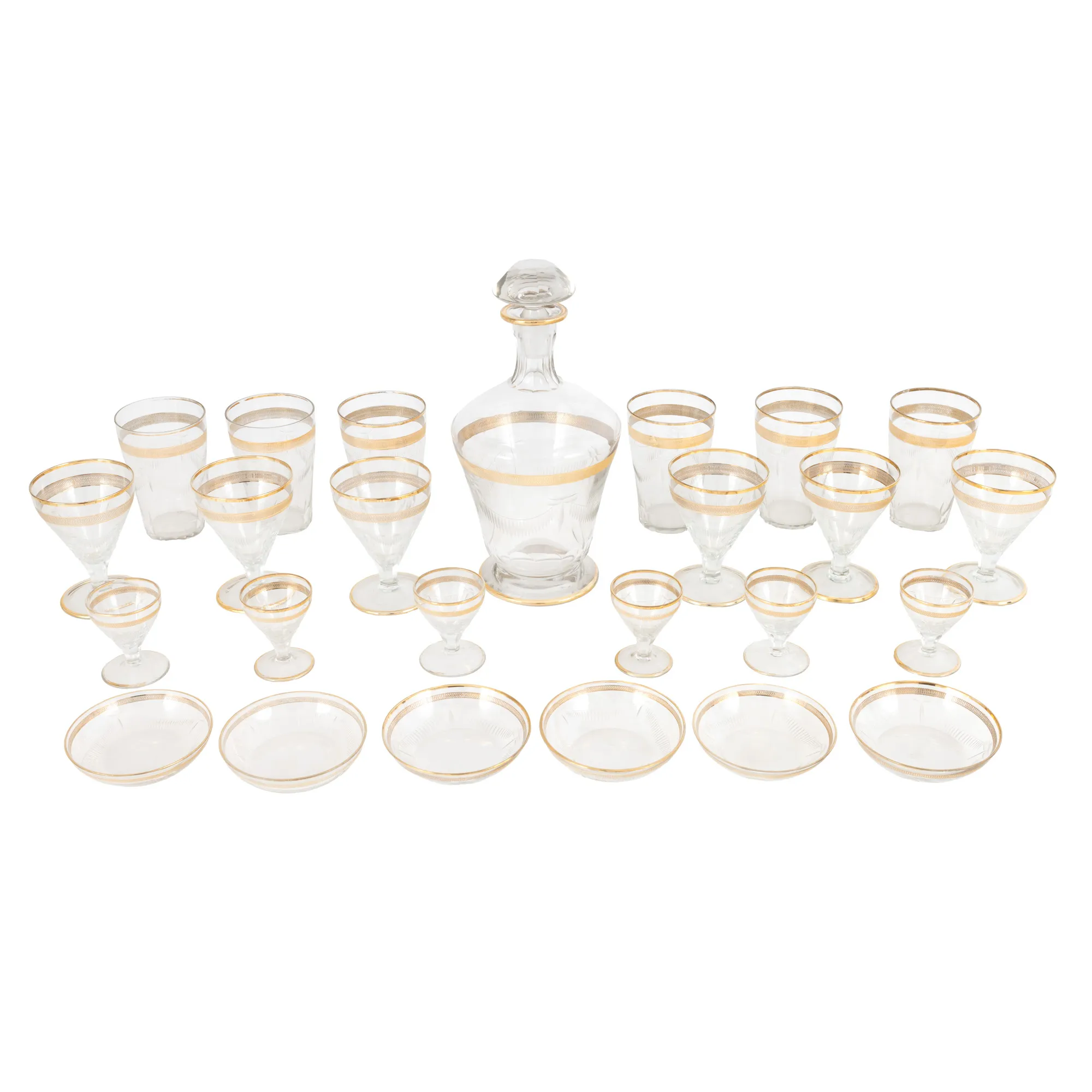 Amplu set din cristal gravat, format din șase pahare pentru vin, șase pahare pentru lichior, șase pahare pentru apă, decantor și șase farfurii pentru dulceață, decorat cu frize aurii