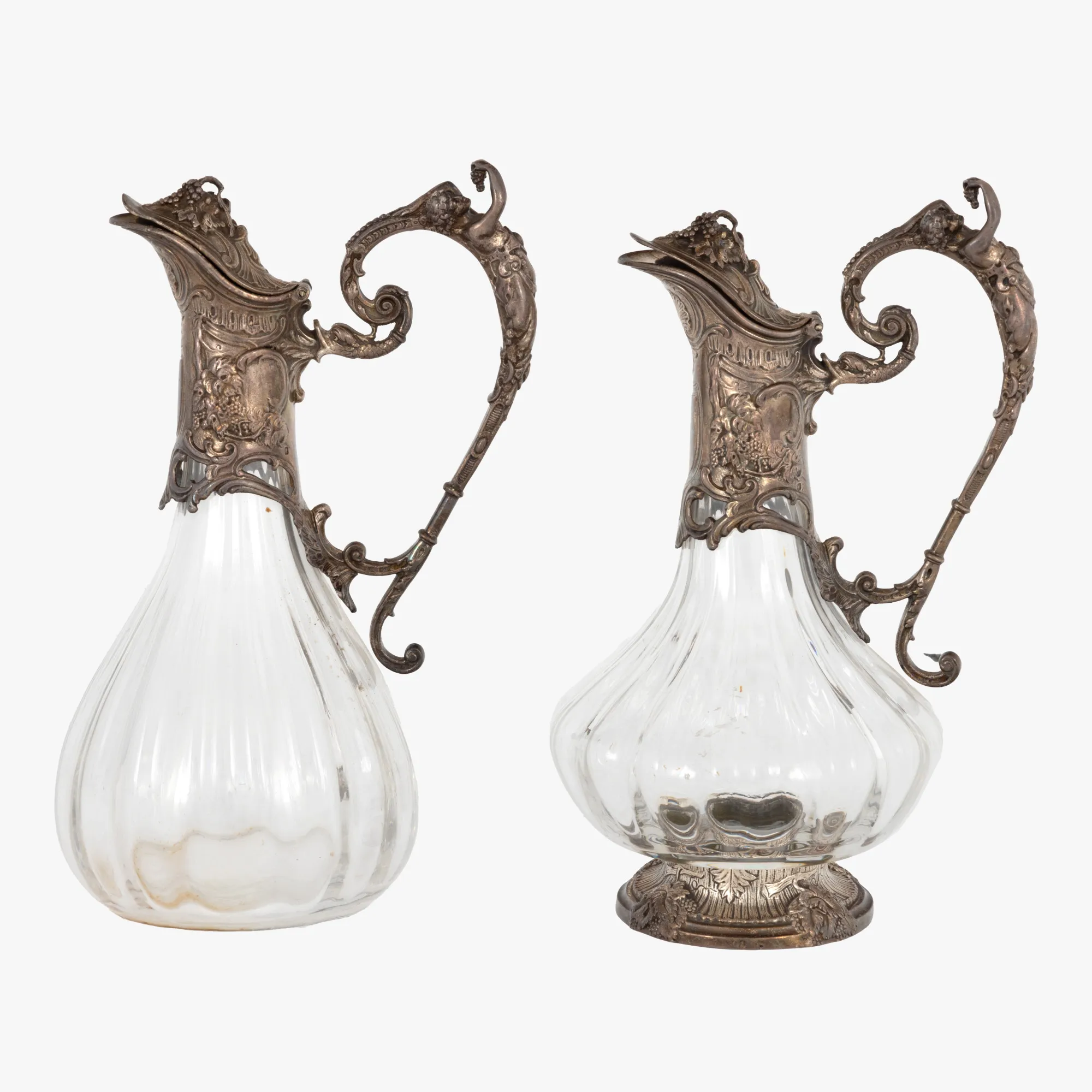 Pereche de carafe în manieră Art Nouveau, din cristial și argint, decorată cu simboluri bahice, prima parte a sec. XX, provine din colecția generalului Mihai Caraman