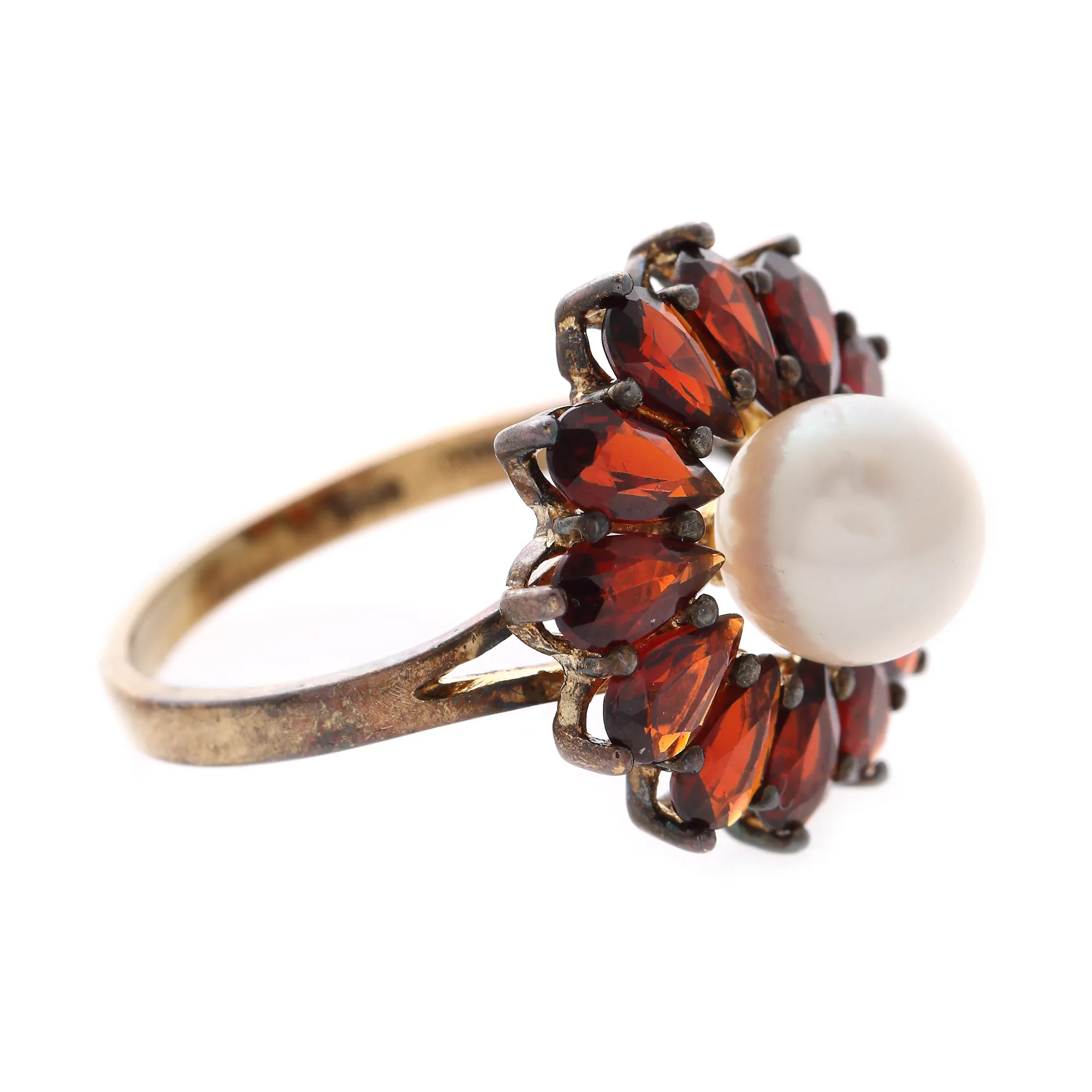 Gold ring decorated with Akoya pearl surrounded by garnets