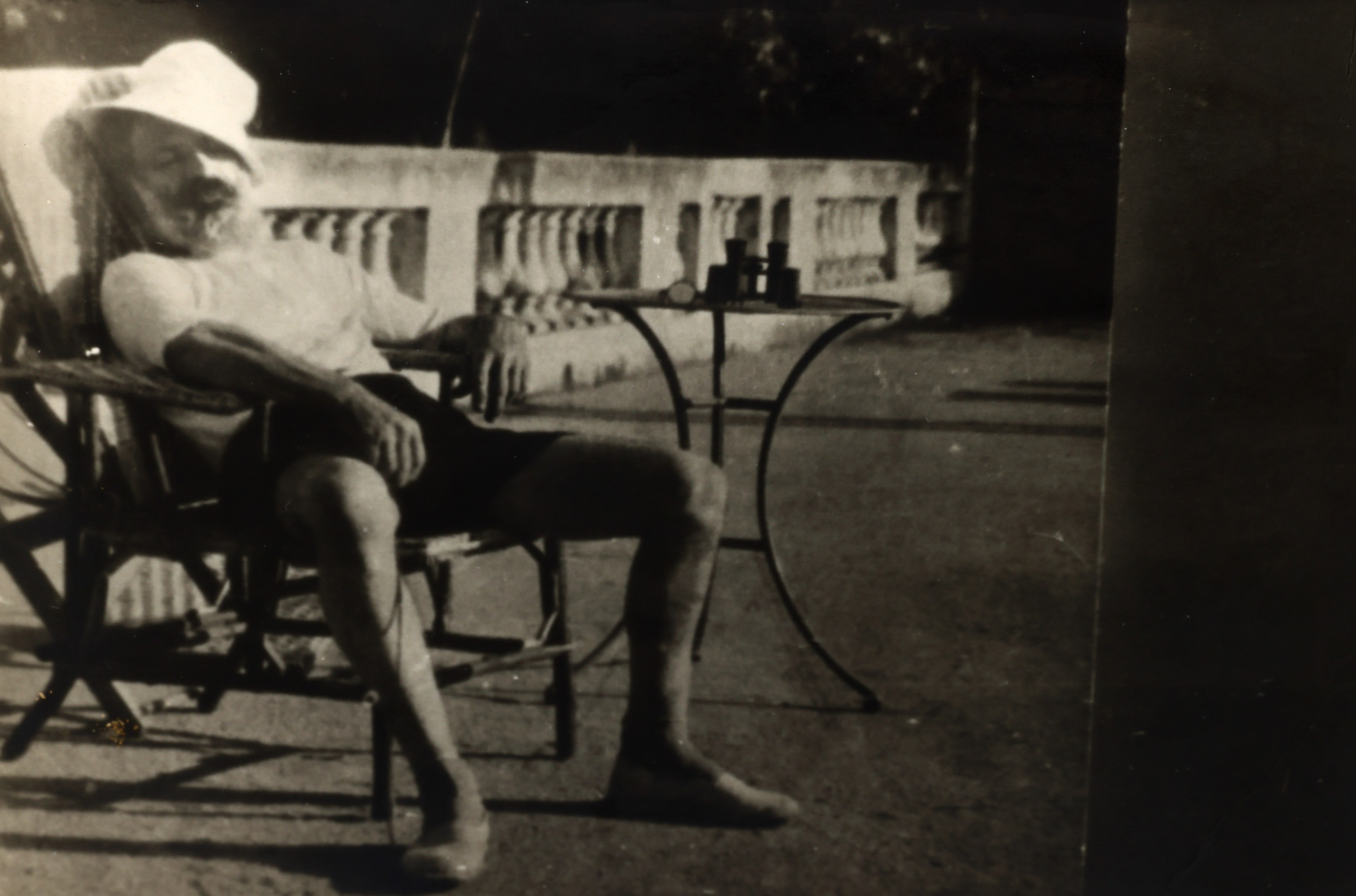 Fotografie ilustrându-l pe Constantin Brâncuși într-un fotoliu de ratan pe terasa Villa Marguerite, în vizită la Mary Reynolds și Marcel Duchamp, Villefranche-sur-Mer, Franța, septembrie 1931