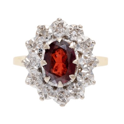 Bicolor gold ring, adorned with a garnet surrounded by diamonds