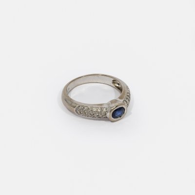 White gold ring, decorated with a sapphire and diamond pavement