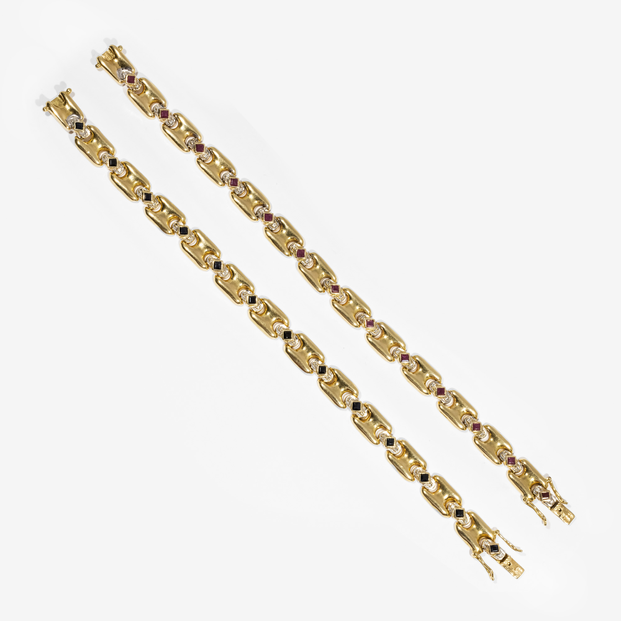 Pair of gold bracelets, decorated alternately with rubies and diamonds, sapphires and diamonds.