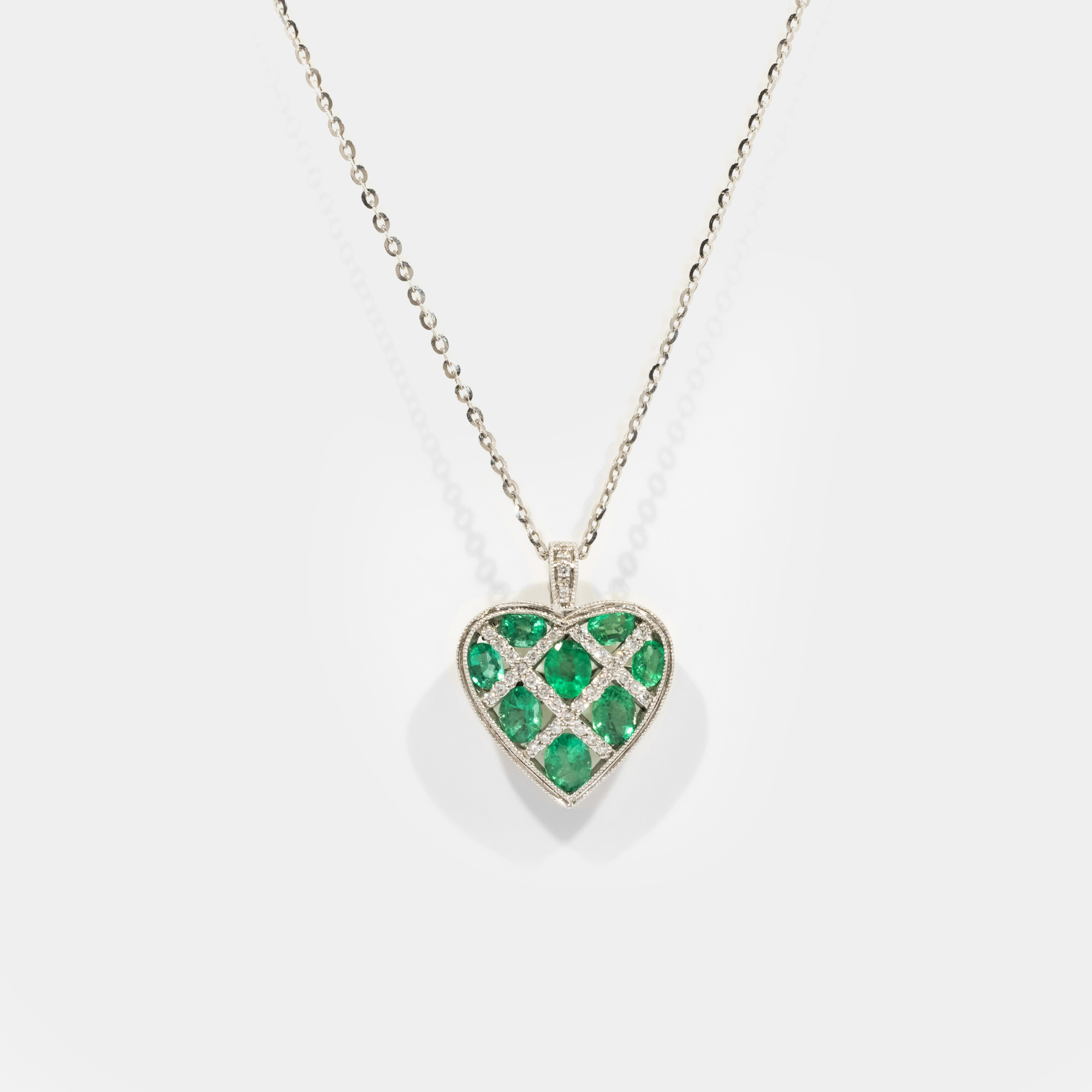 Emeralds International white gold necklace with heart-shaped pendant, decorated with Colombian emeralds and diamonds, accompanied by additional gemological certificate