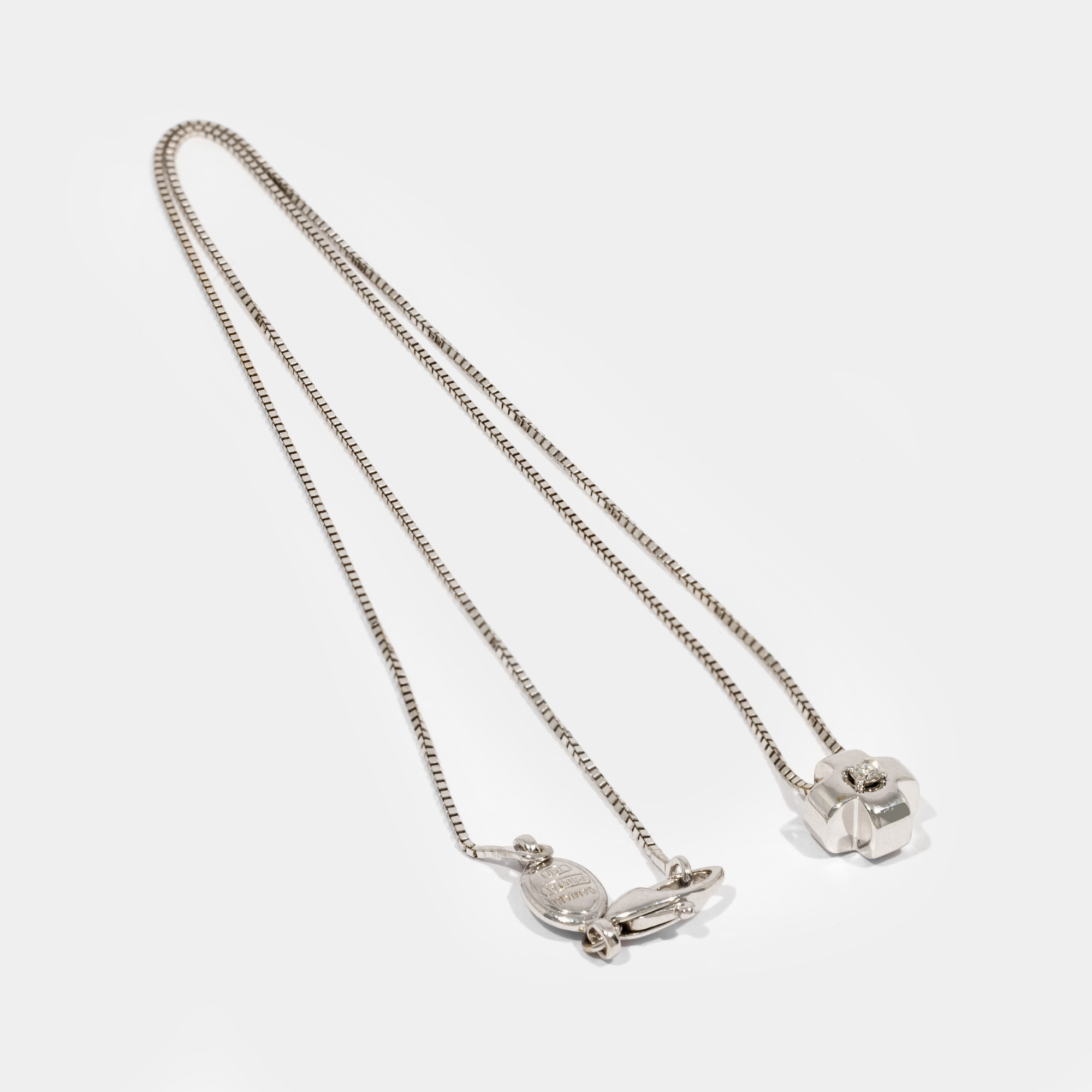 Damiani pendant chain, in white gold, in the shape of a cross, decorated with a diamond, accompanied by an additional gemological certificate