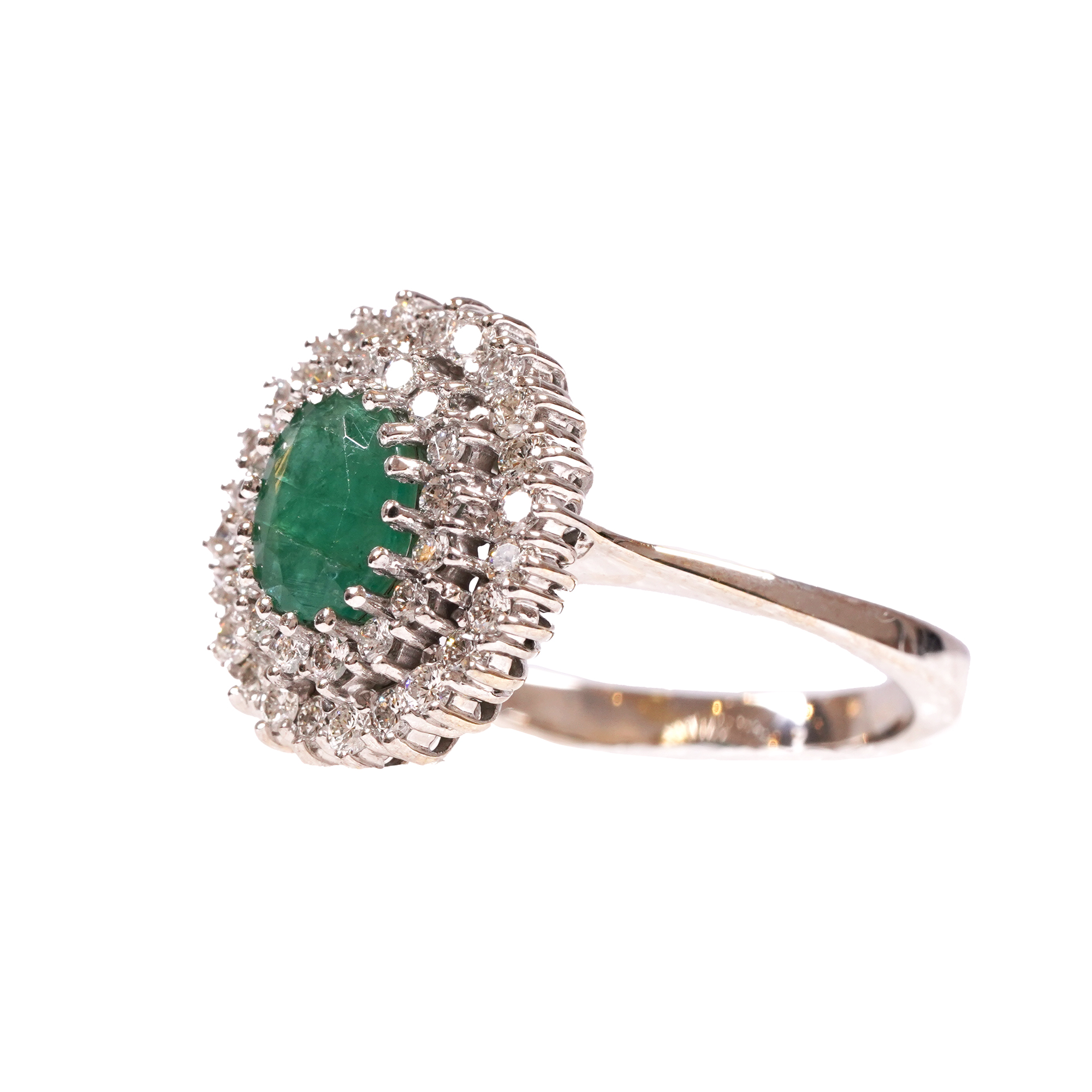 White gold ring set with an emerald surrounded by diamonds