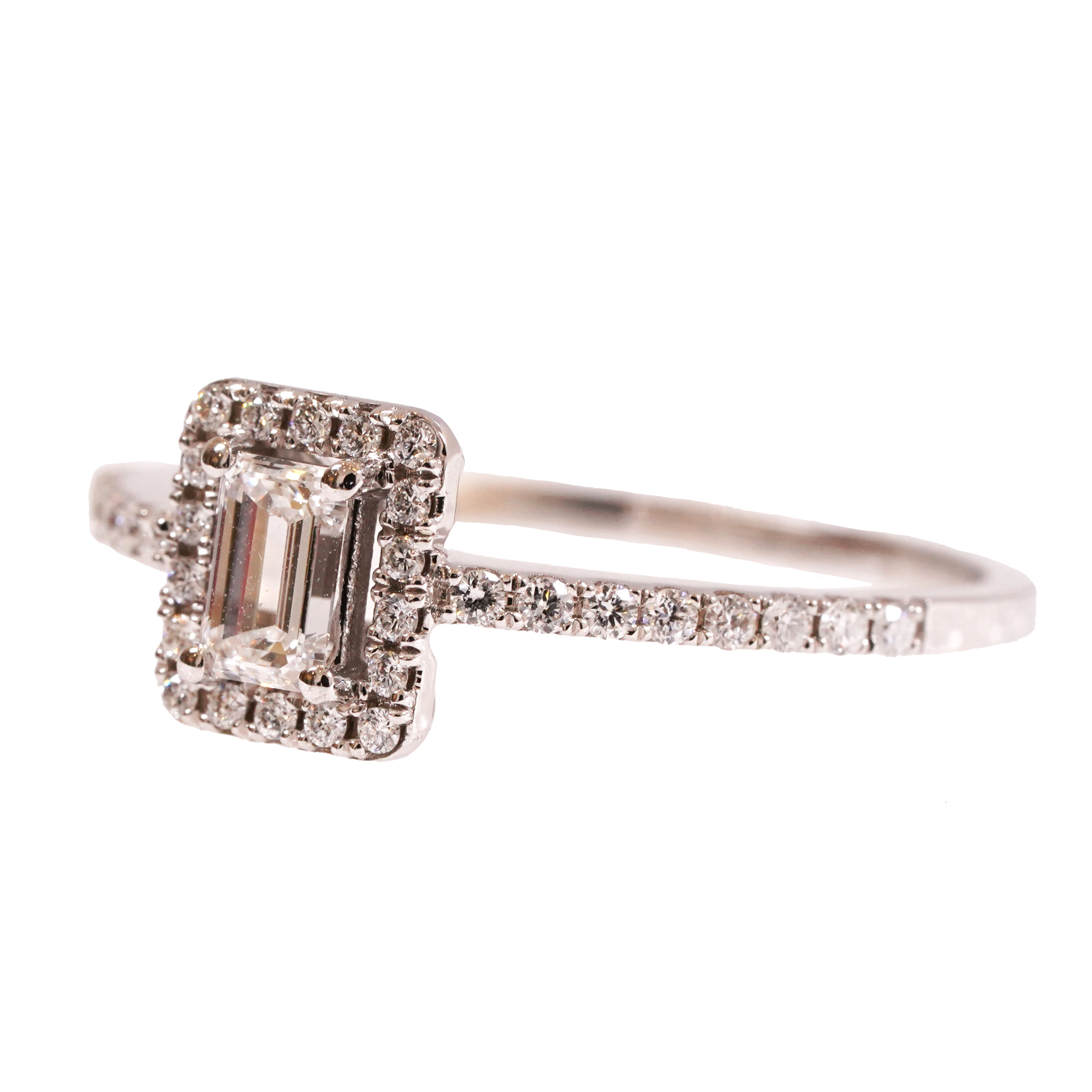 White gold ring decorated with an emerald-cut diamond surrounded by brilliants