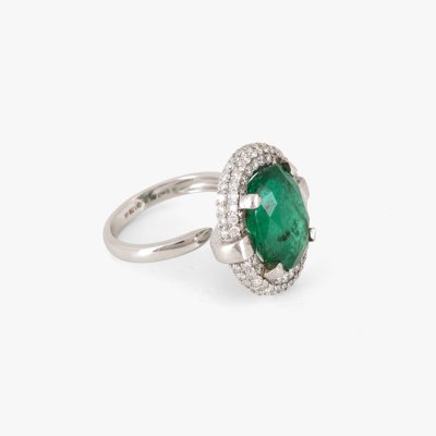 White gold ring, decorated with emerald and double diamond entourage