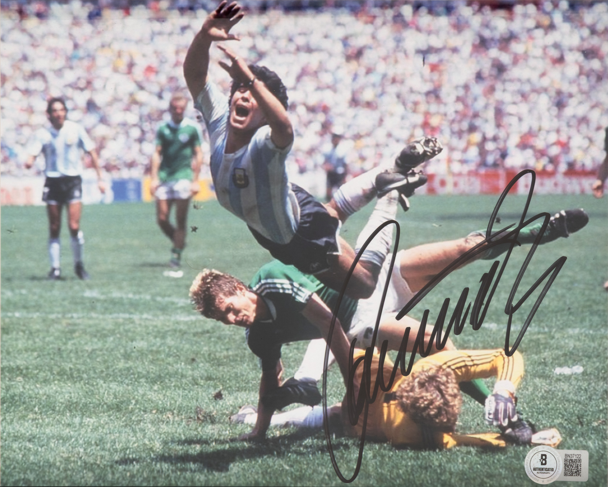 Fotografie reprezentându-i pe Diego Maradona, respectiv Harald Schumacher și Karl Heinz Foerster, în finala de la Cupa Mondială 1986, Argentina vs. Germania de Vest, cu semnătura olografă a lui Harold Schumacher, înrămată