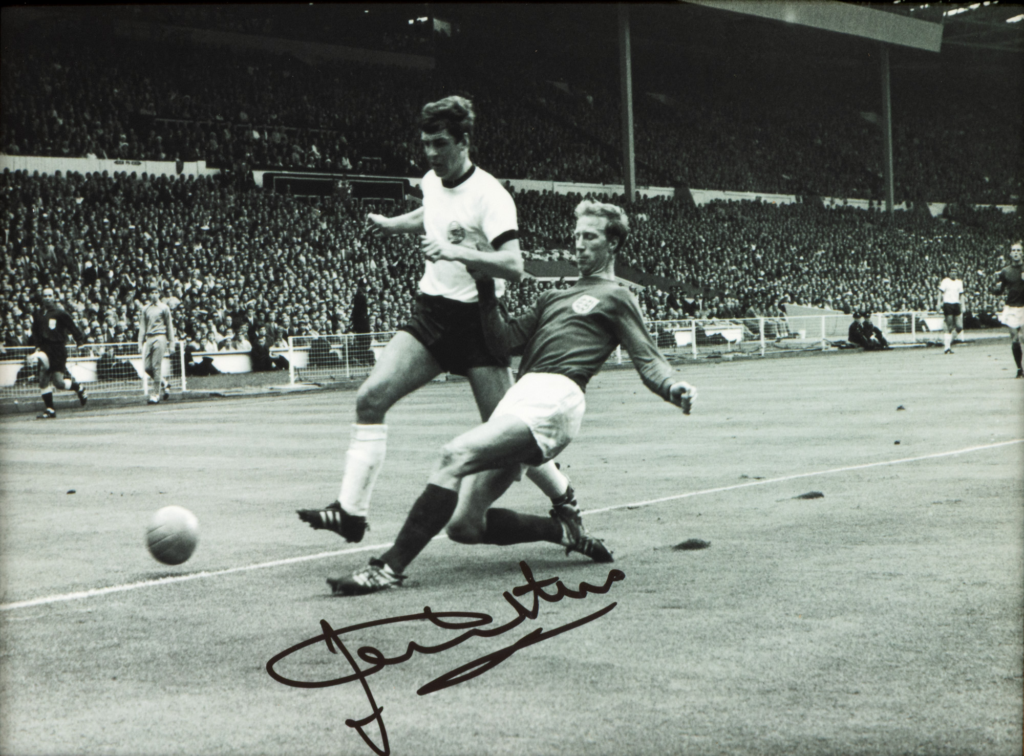 Fotografie reprezentându-l pe Jack Charlton, în timpul unui meci pentru reprezentativa Angliei din 1966, cu semnătura olografă a sportivului, înrămată