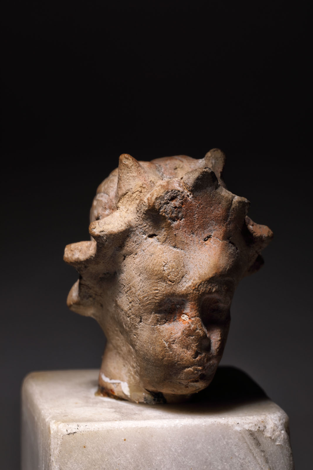 Fragment de statuetă din teracotă, ilustrând un cap de femeie cu coroană de iederă, epocă greco-romană, provine din colecția dr. Horia Slobozianu