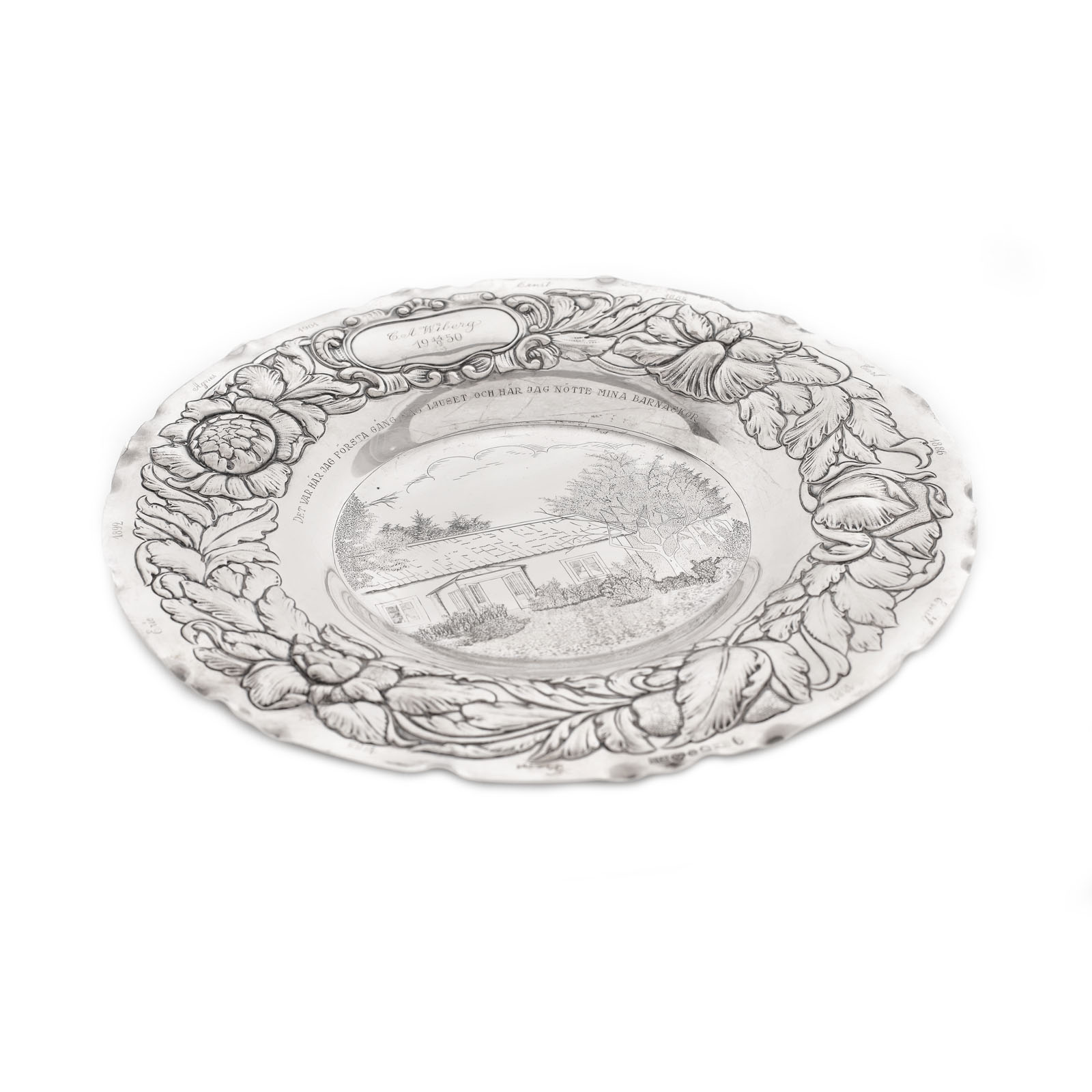 Silver platter, with an engraved decoration at the centre and an au repoussé border