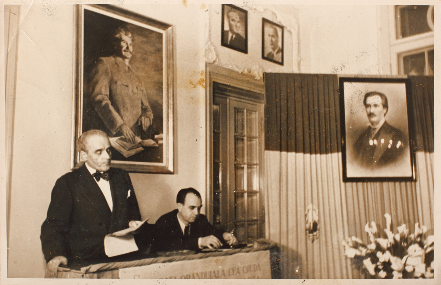 Fotografie surprinzându-l pe scriitorul Cezar Petrescu, preluând cuvântul la Uniunea Scriitorilor, plasat între cele două portrete, al lui Mihai Eminescu şi al lui Stalin, 12 ianuarie 1950