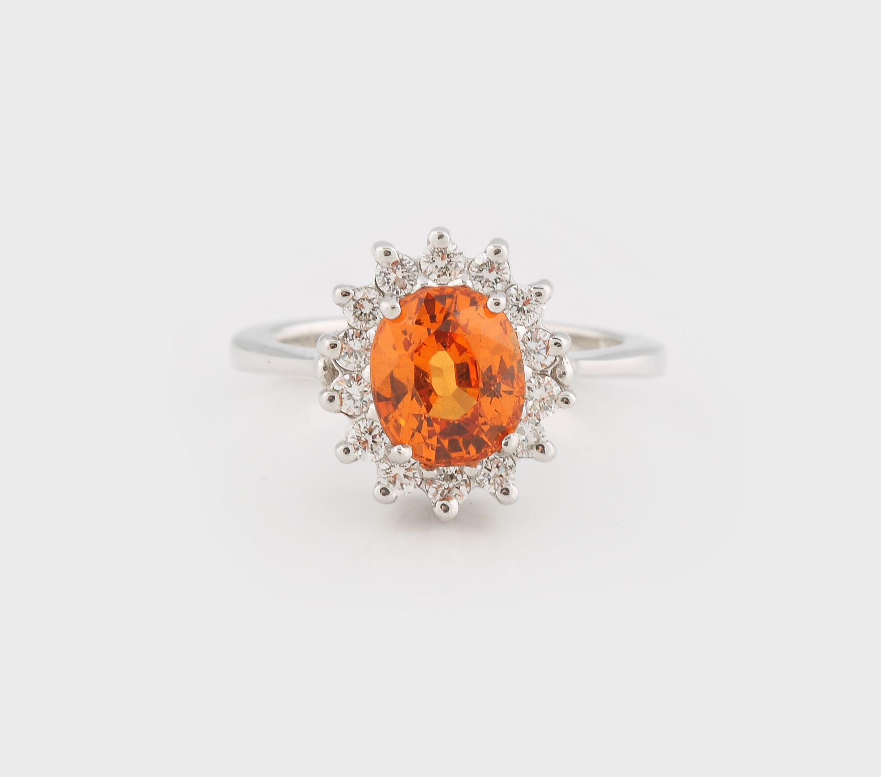 Inel din aur alb, decorat cu un granat oranj anturat de diamante