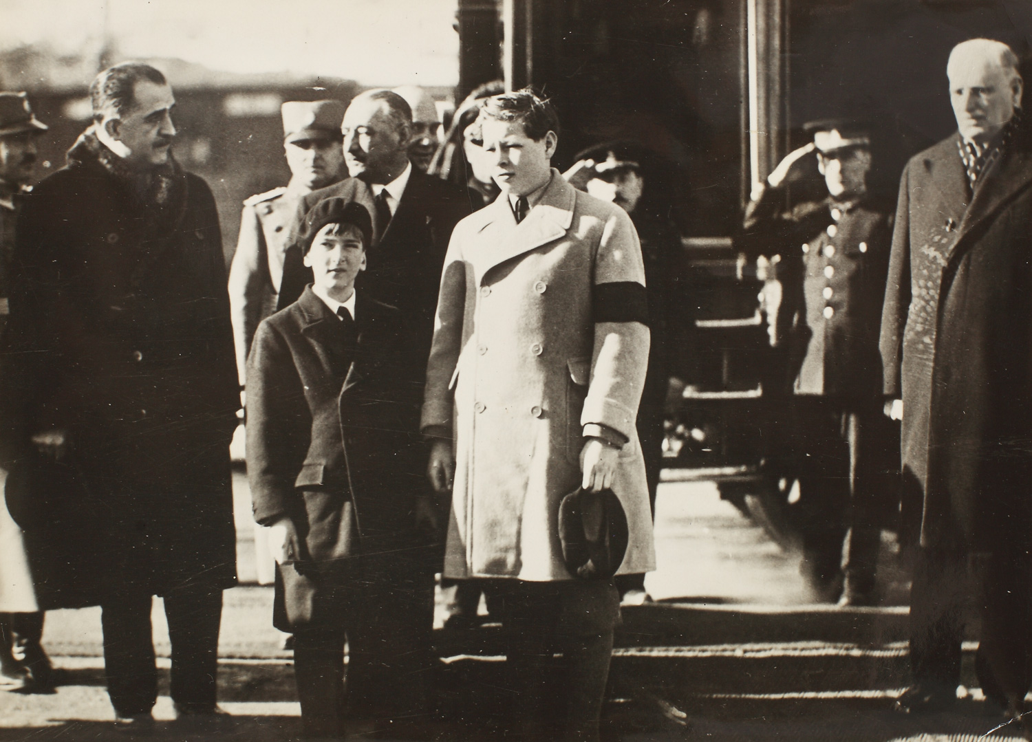 Fotografie de presă înfăţişându-l pe Principele Mihai alături de tânărul Rege Petru al II-lea al Iugoslaviei la ceremonia de înmormântare a lui Alexandru I, unchiul prin alianță al lui Mihai, asasinat la Marsilia în 1934
