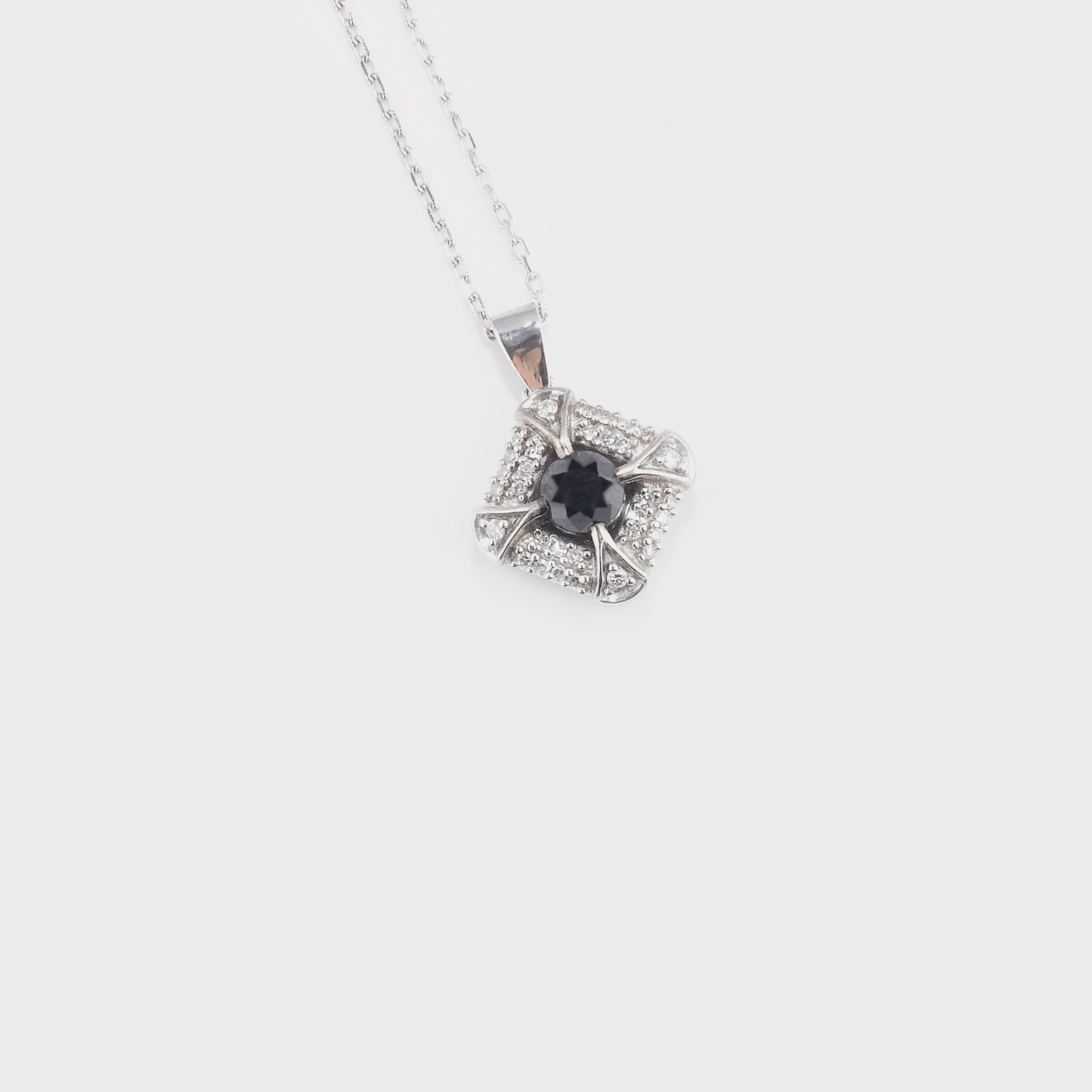 Elegant pandantiv din aur alb, decorat cu diamante albe şi un diamant negru